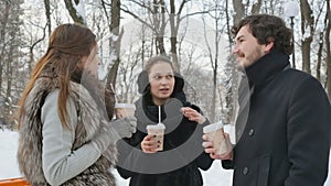 Pleasant people in the winter snow-covered park drinks a coffee