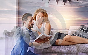 Calm loving couple looking attentive while reading an interesting book