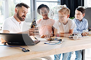 Pleasant robotics specialist conducting a workshop for children