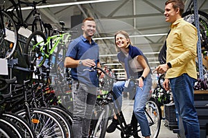 Pleasant salesman try to sell sportive bicycle for customers