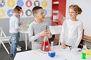 Pleasant schoolchildren thinking about chemistry project