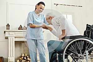 Pleasant senior man holding caregivers hand