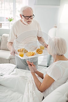 Pleasant senior man holding a tray with food