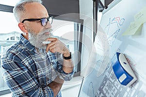 Pleasant skillful man is working in office