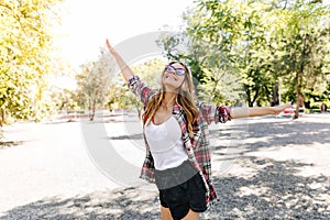 Pleasant slim girl dancing in summer park. Positive caucasian lady funny posing on nature backgroun