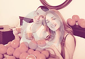 Pleasant smiling couple with ripe oranges and freshly juice