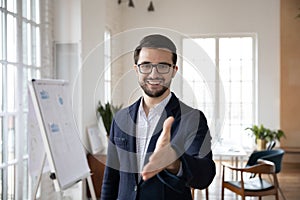 Pleasant smiling trustful manager in suit reaching out hand. photo