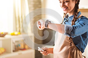 Pleasant smiling woman standing in the kitchen.