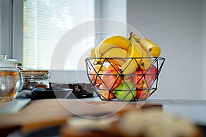 Pleasant sunlight accentuates a banana in a glass bowl on the kitchen counter