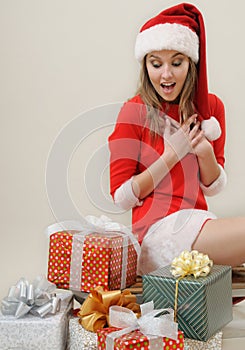 A pleasant surprise girl in Santa hat with gifts for Christmas