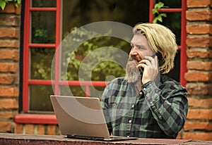 pleasant talk. bearded man in cafe with laptop and phone. online distant education. hipster inspired to work. agile