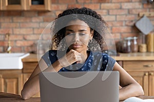 Pleasant thoughtful young african american businesswoman working on computer.