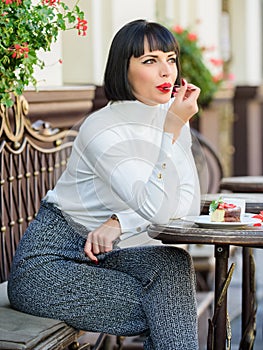 Pleasant time and relaxation. Delicious gourmet cake. Woman attractive brunette eat gourmet cake cafe terrace background