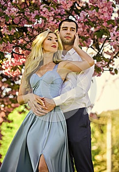 Pleasant time spending. couple in love kiss and embrace. spring flower bloom. man and woman in park with pink blossoming