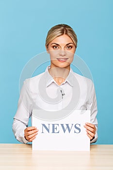 Pleasant TV announcer sitting at the table