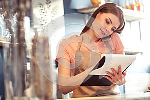 Pleasant waitress talking on mobile phone