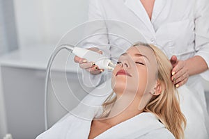Pleasant woman with closed eyes receiving beauty treatment