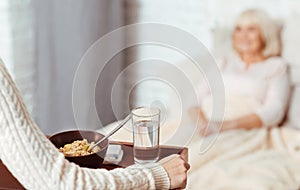 Pleasant woman holding tray with breakfast