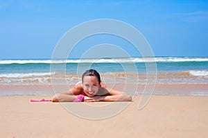 Pleasant woman lying on the sand