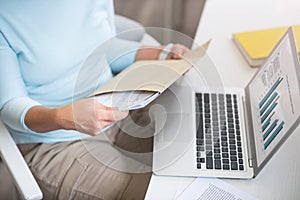 Pleasant woman opening envelope