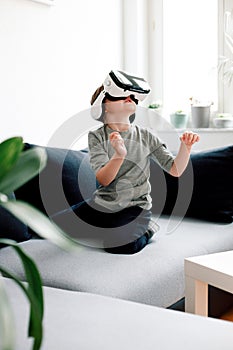 Pleasant young girl wearing VR glasses for the first time feeling exited