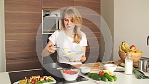 Pleasant young woman preparing dinner in a kitchen concept cooking.