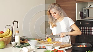 Pleasant young woman preparing dinner in a kitchen concept cooking.