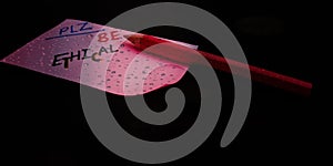 please be ethical concept displaying with black water drops abstract background photo