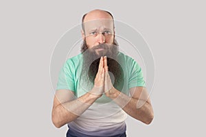 Please help me, forgive me or give me one chance more. Portrait of pleased middle aged bald bearded man standing with palm hands,