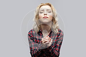 Please help me. Portrait of beautiful blonde young woman in casual red checkered shirt standing with hands palm and looking at