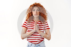 Please help me. Sincere worried redhead cute curly-haired woman begging favour press arms together plead supplication