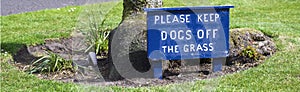 Please keep dogs off the grass sign