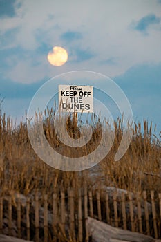 Please keep off the dunes sign under a full moon.