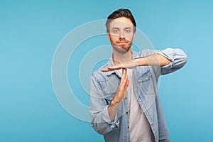 Please, need pause! Portrait of man in worker denim shirt showing time out, refusing and doing enough limit gesture