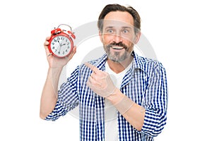 Please observe time. Mature man pointing finger at alarm clock. Mature timekeeper with analog clock. Bearded senior man