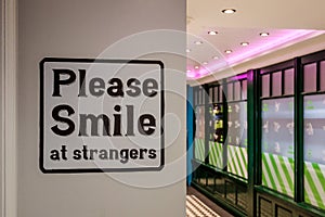 Please smile at stranger sign