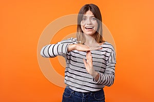 Please, time out! Portrait of worried upset young woman with brown hair in long sleeve striped shirt. indoor studio shot 