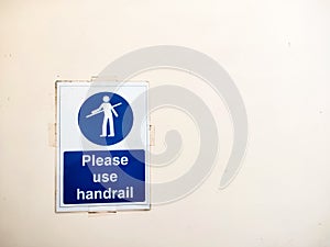 Please use handrail sign poster on wall near escalator