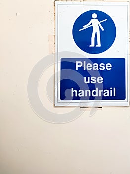 Please use handrail sign poster on wall near escalator