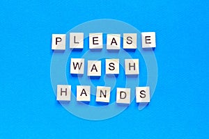 Please wash your hands, written in wooden letters on a blue background, warning, request, top view, flat layout