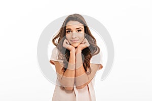 Pleased brunette woman in t-shirt reclines on her hands