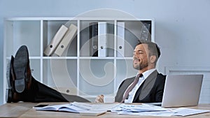 pleased businessman sitting with legs on