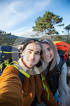 Pleased couple of hikers taking selfie