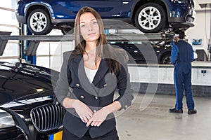 Pleased customer standing in front of her fixed car