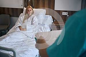 Pleased female patient being served meal in medical facility ward