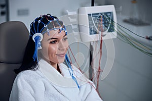 Pleased female patient undergoing an EEG test