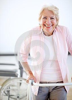 Pleased with her progress. Portrait of a delighted female patient getting to grips with her new zimmer frame.