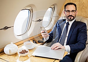 Pleased middle aged man enjoying first class flight