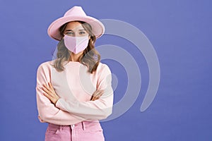 Pleased nice girl posing in protective mask and pink hat