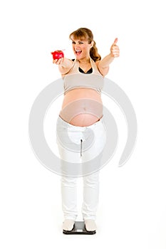 Pleased pregnant woman showing thumbs up